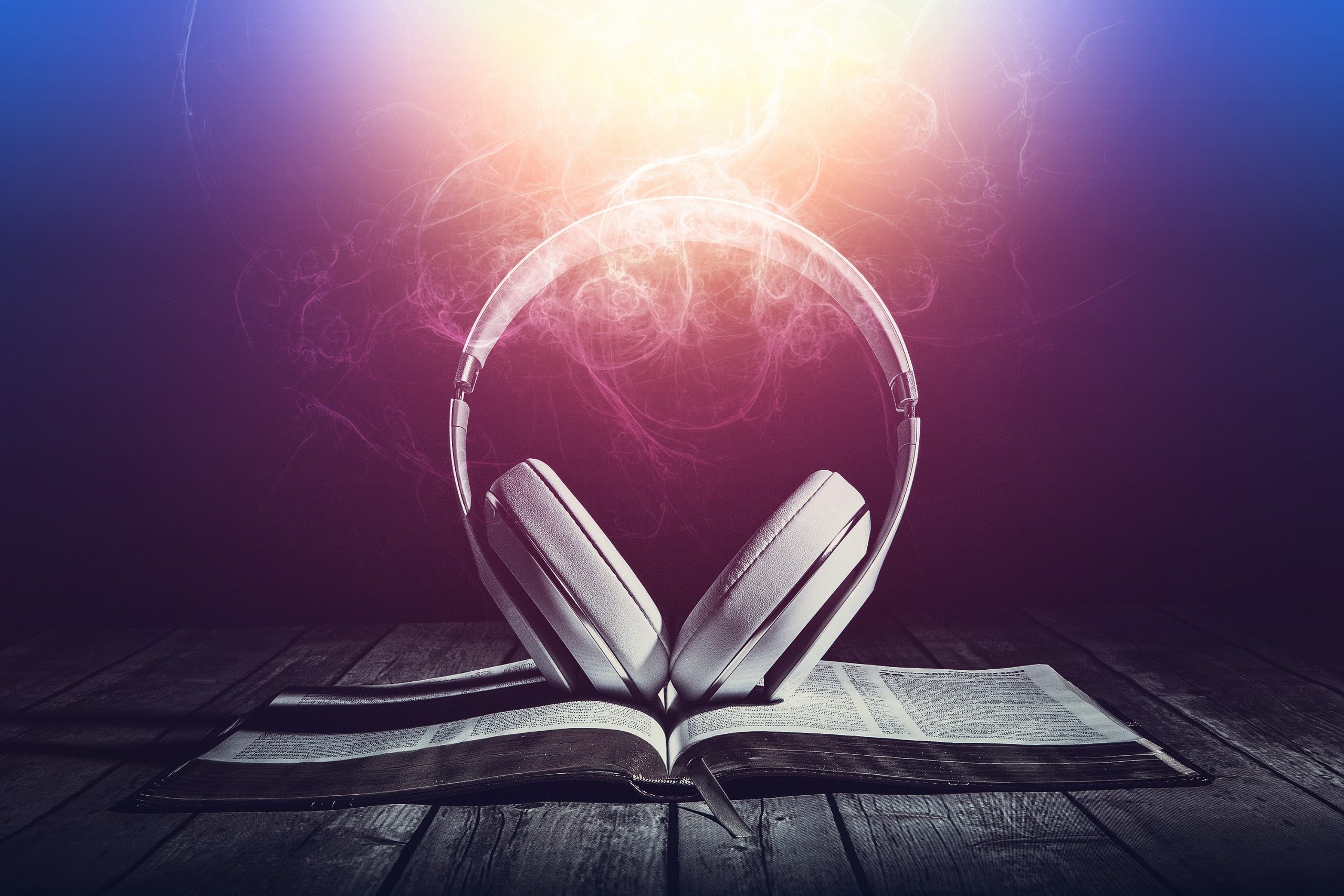 A pair of headphones on top of an open book with electrical soundwaves around it