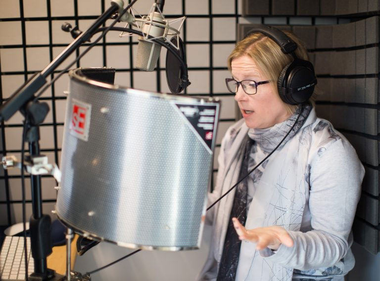 Esther narrating a book in her professional soundproof studio