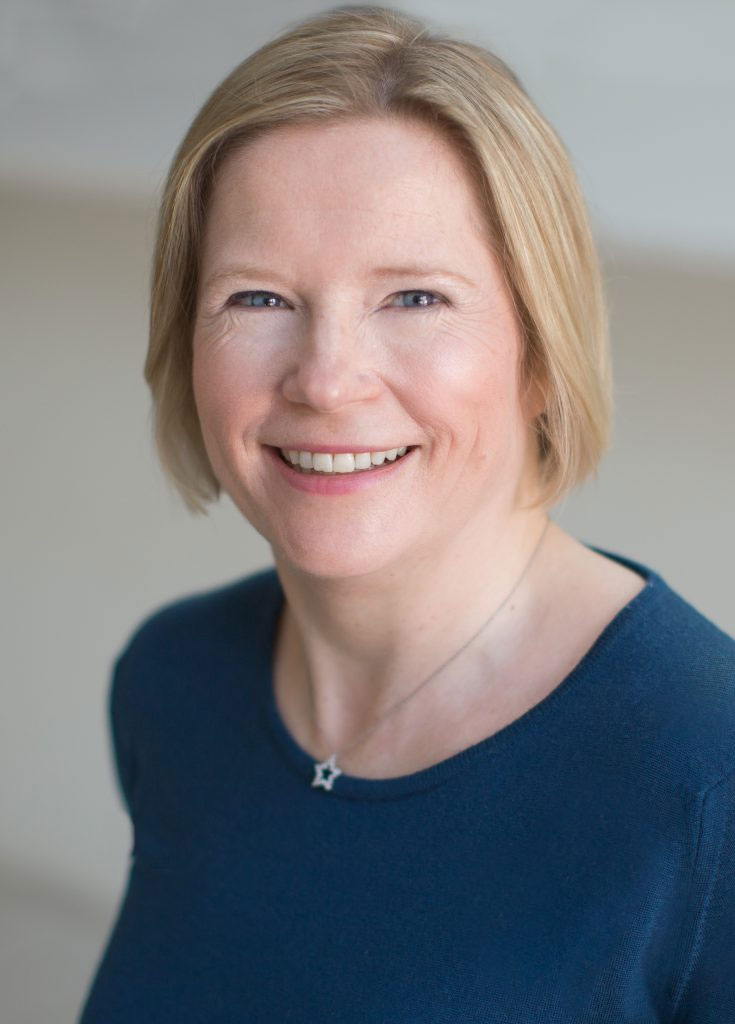 Professioanl headshot of Esther Wane smiling with a dark blue shirt on